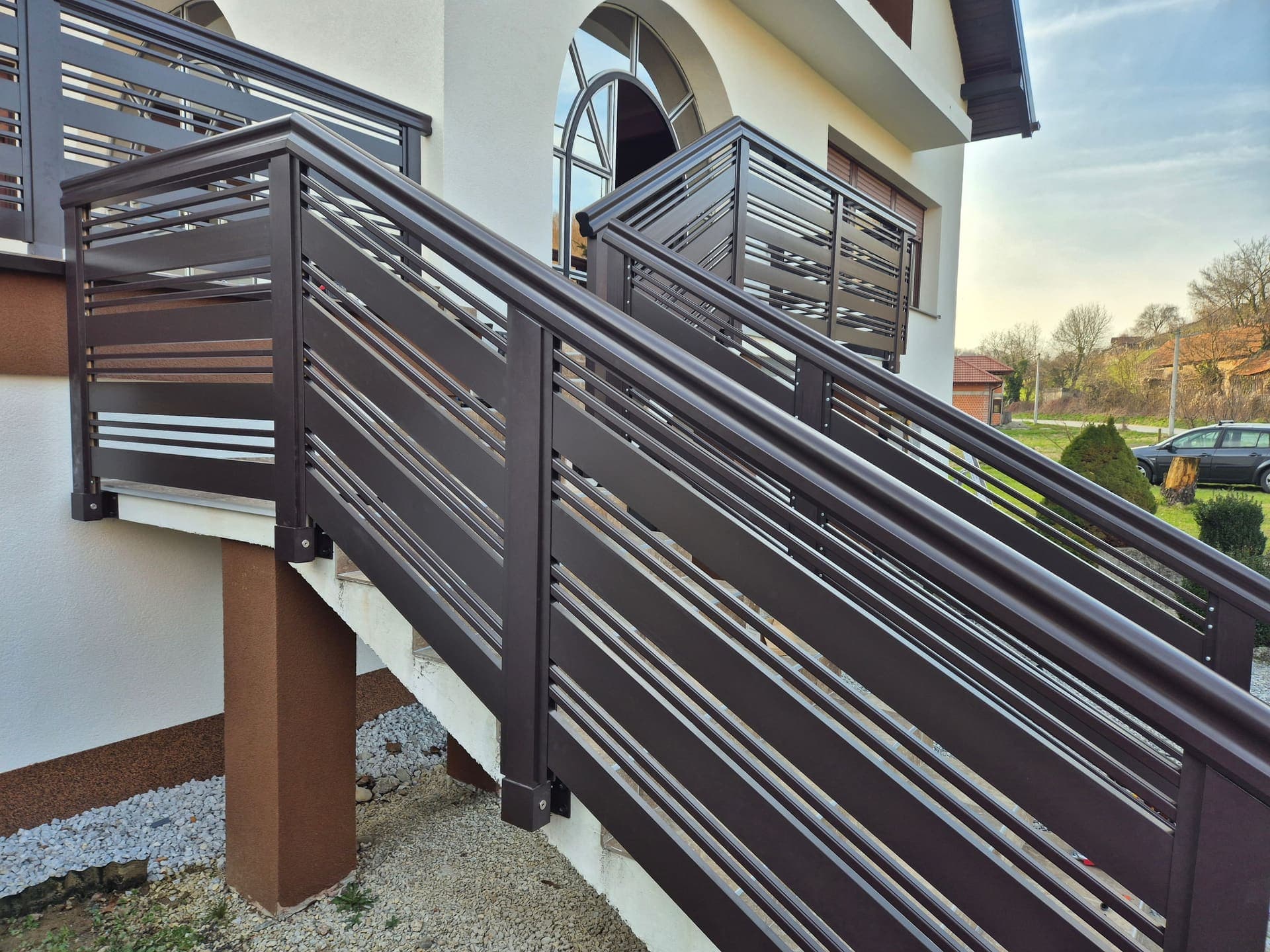 Aluminijska ograda antracit boje s vodoravnim letvicama ispred obiteljske kuće