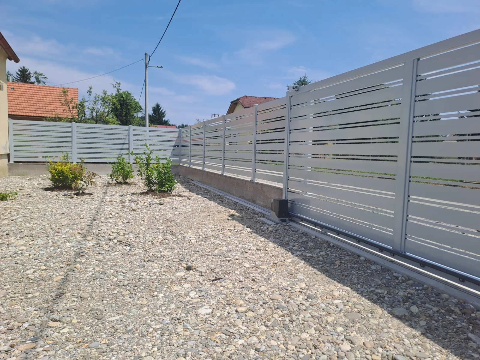Klizna dvorišna vrata od aluminija s ogradom iz istog modela uz prilaz obiteljskoj kući
